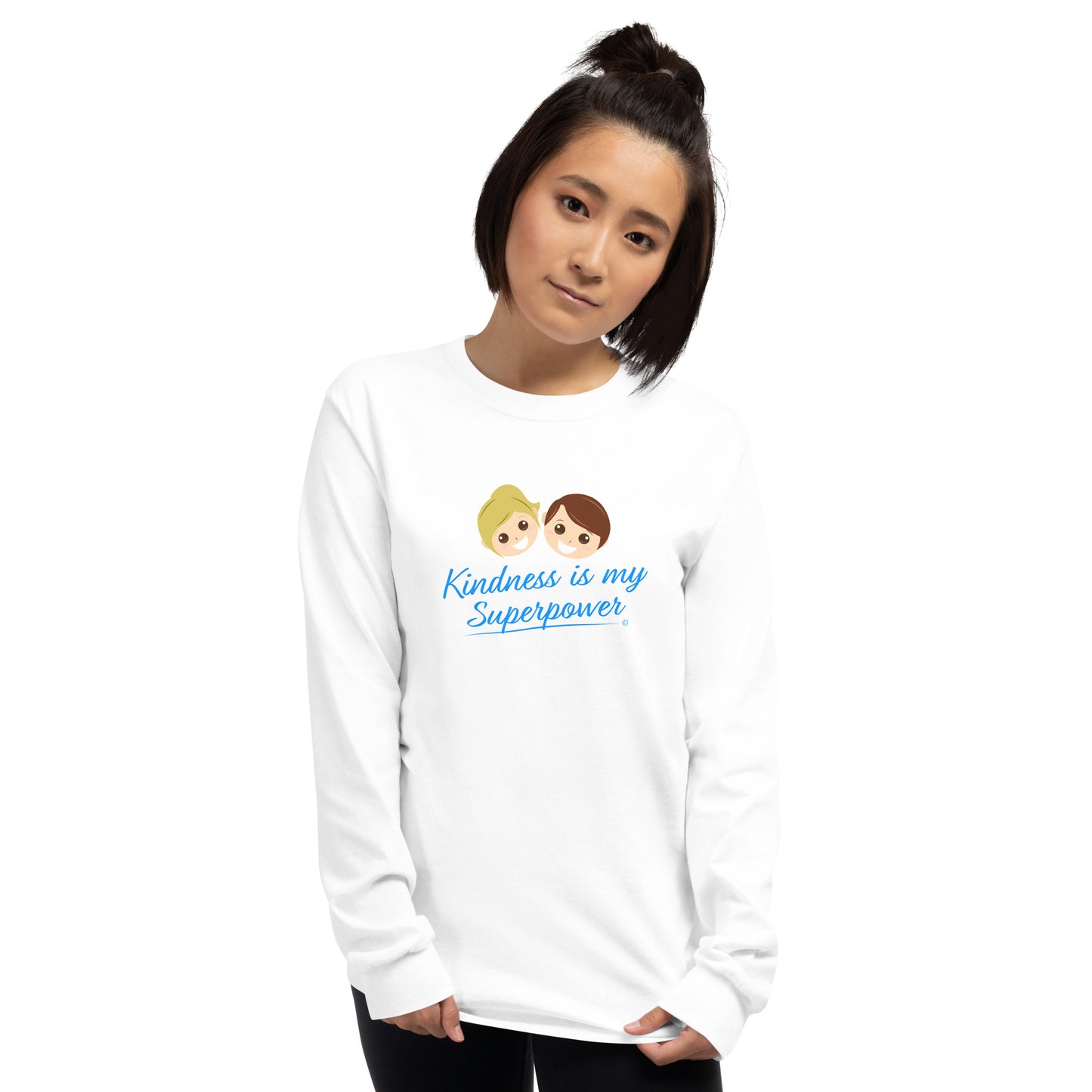 A confident young woman wearing a stylish long sleeve shirt in white, featuring the empowering quote 'Kindness is my Superpower' in bold lettering.