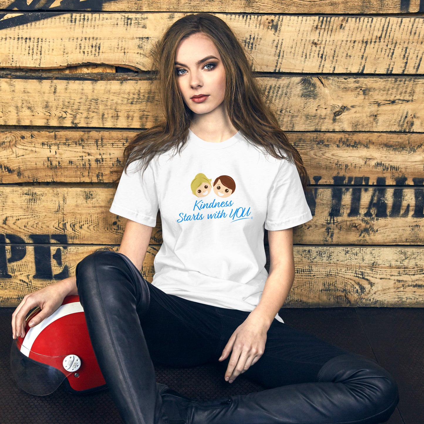 A confident young woman proudly modeling a versatile white unisex t-shirt with the inspiring quote 'Kindness Starts with You' in bold lettering.