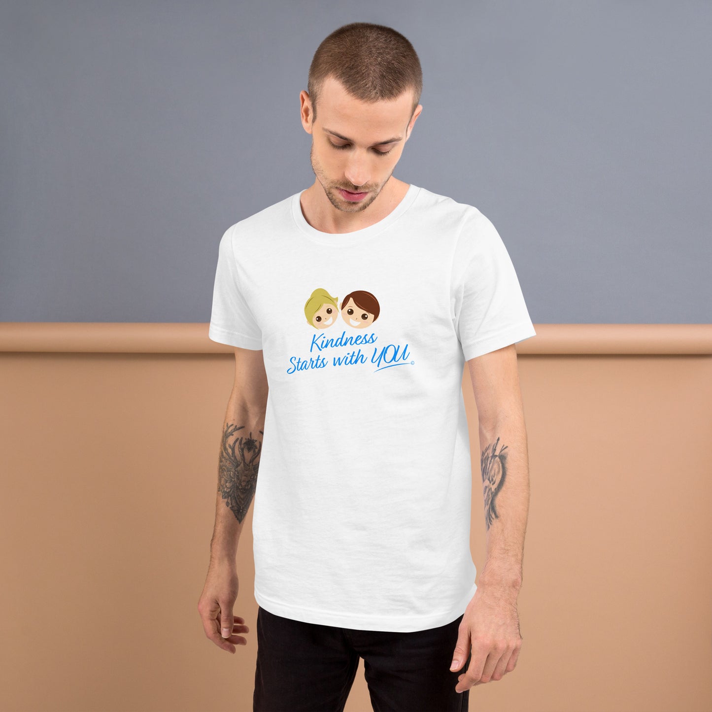 A confident man proudly modeling a versatile white unisex t-shirt with the inspiring quote 'Kindness Starts with You' in bold lettering.