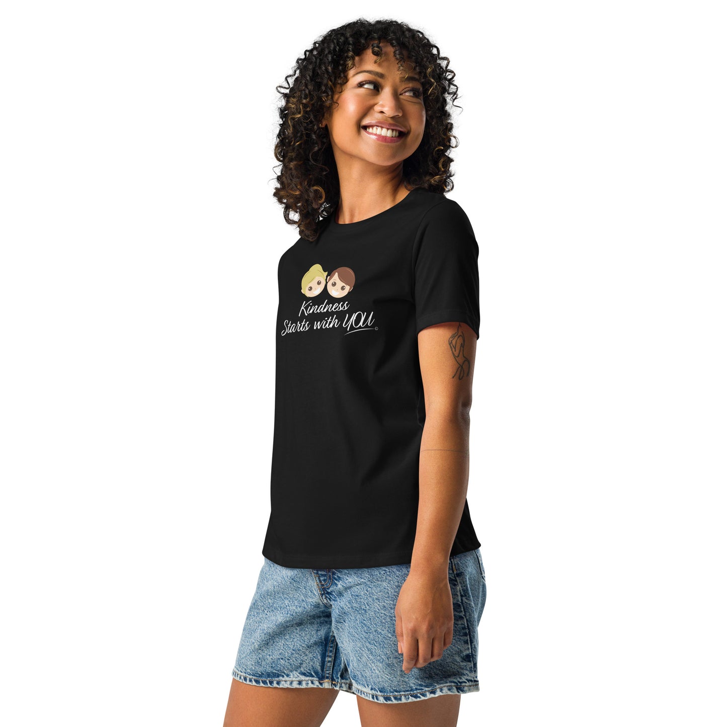 A happy woman showcasing a stylish women's shirt in black, featuring the empowering quote 'Kindness Starts with You' in bold lettering.