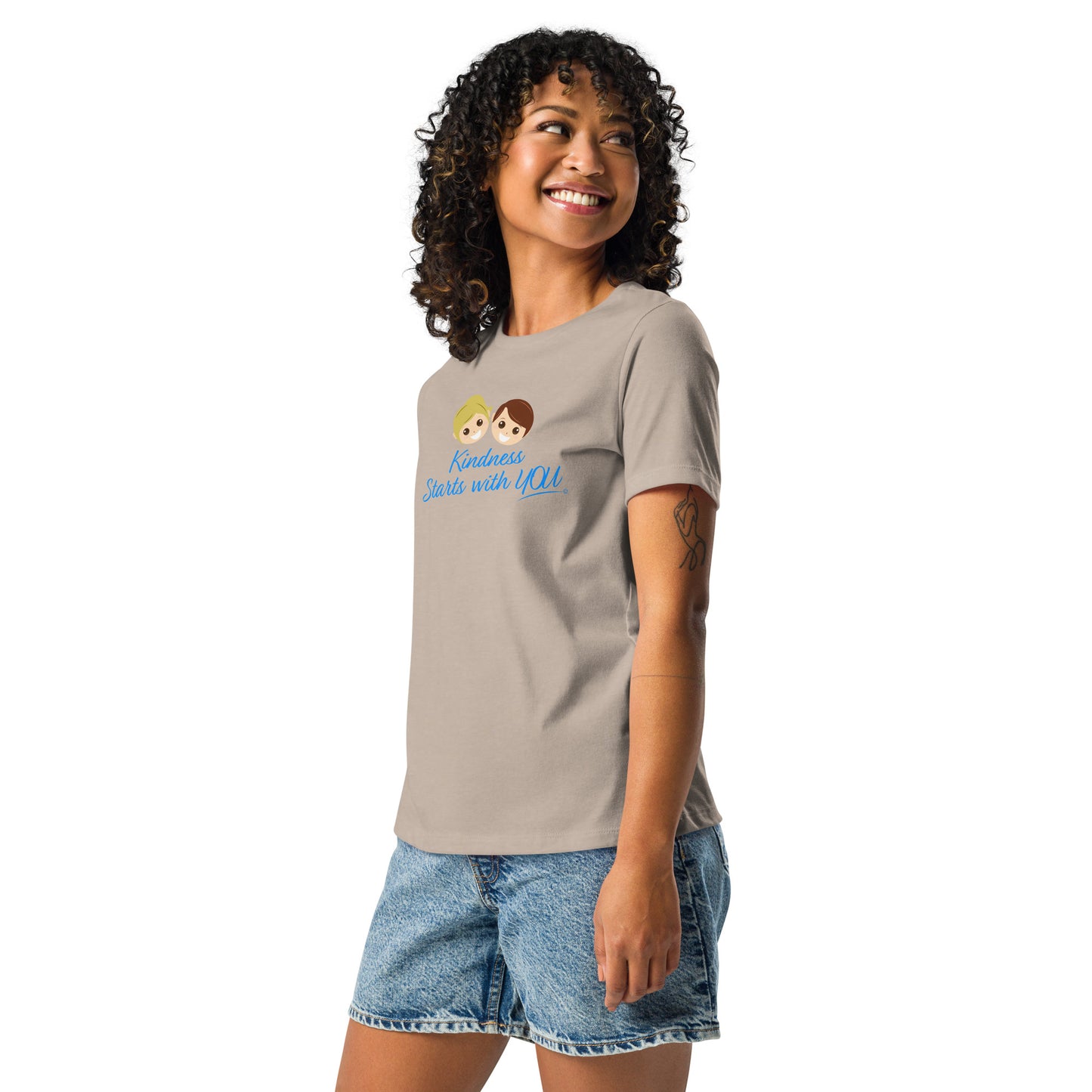 A happy woman showcasing a stylish women's shirt in heather stone, featuring the empowering quote 'Kindness Starts with You' in bold lettering.