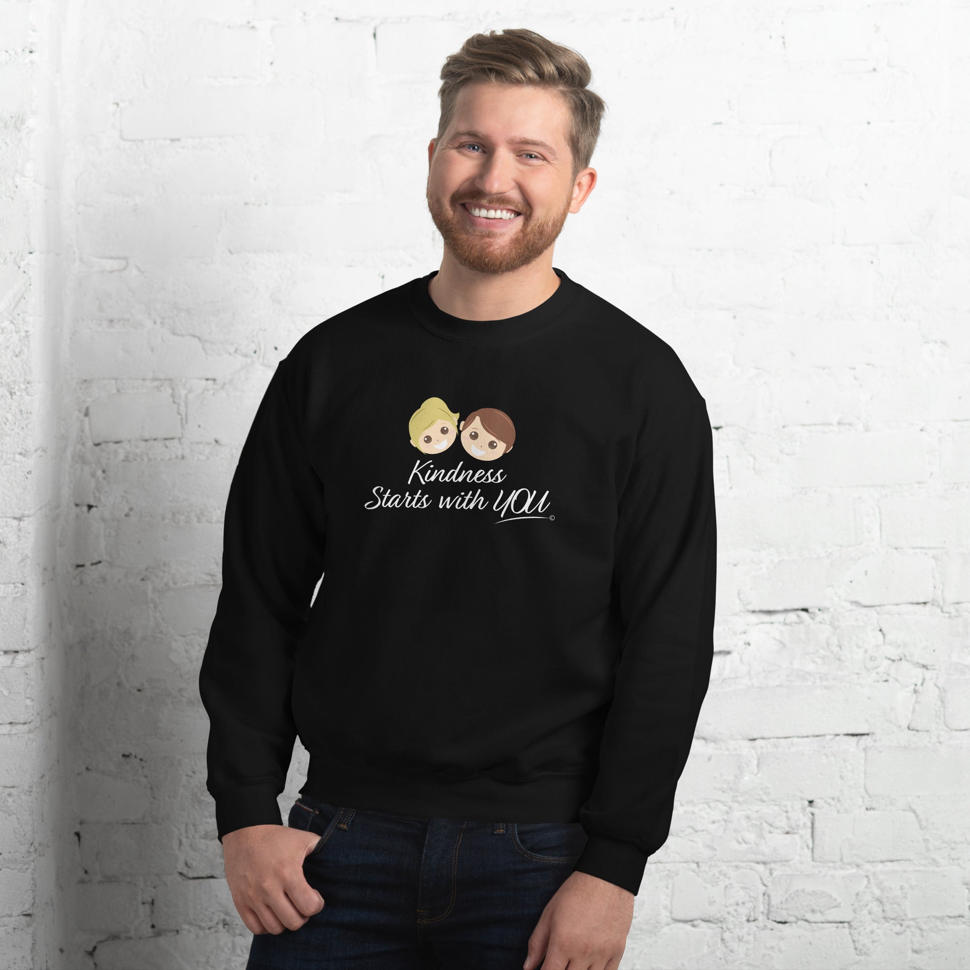 A confident man modeling a cozy unisex sweatshirt in black, featuring the uplifting quote 'Kindness Starts with You' in bold lettering.