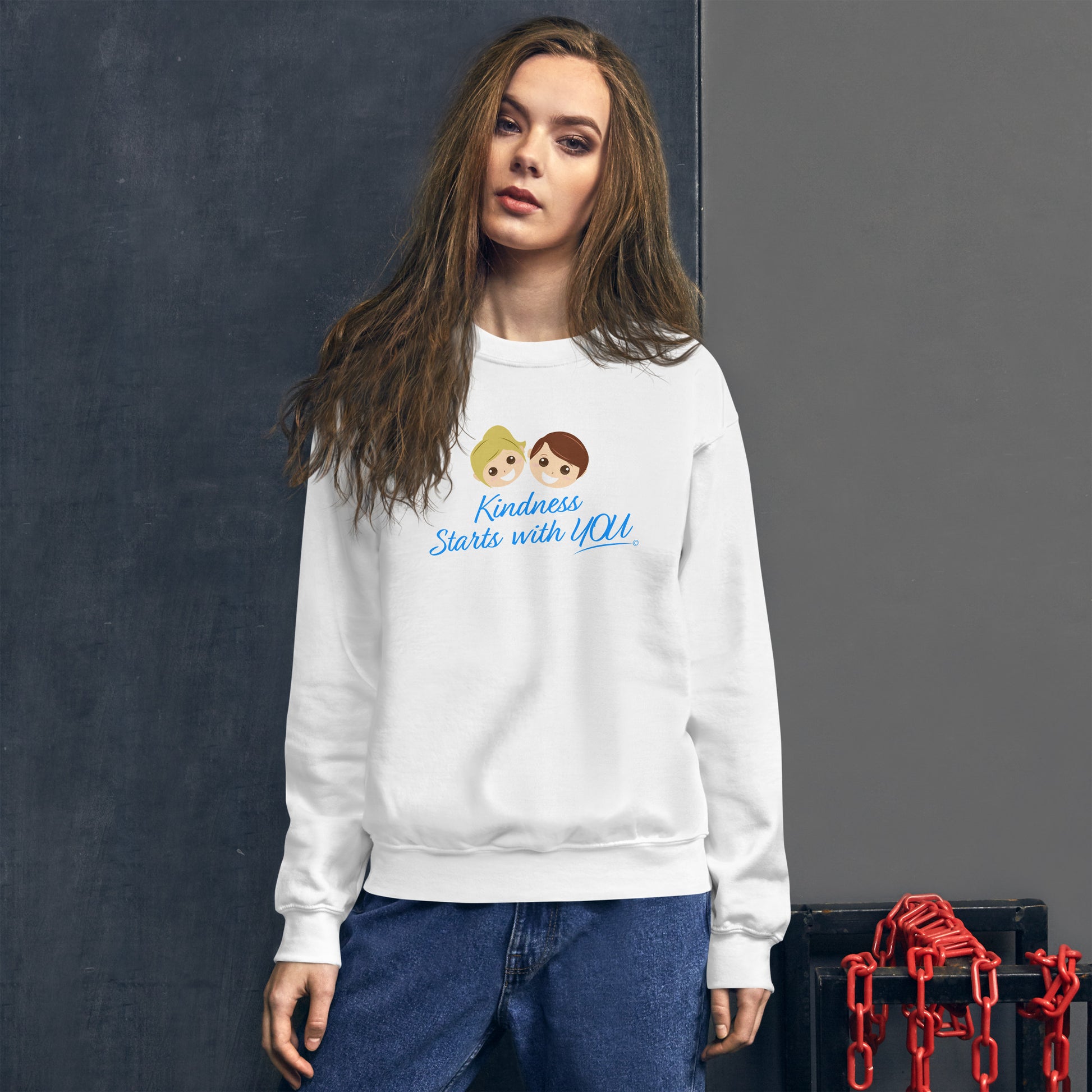 A confident woman modeling a cozy unisex sweatshirt in white, featuring the uplifting quote 'Kindness Starts with You' in bold lettering.
