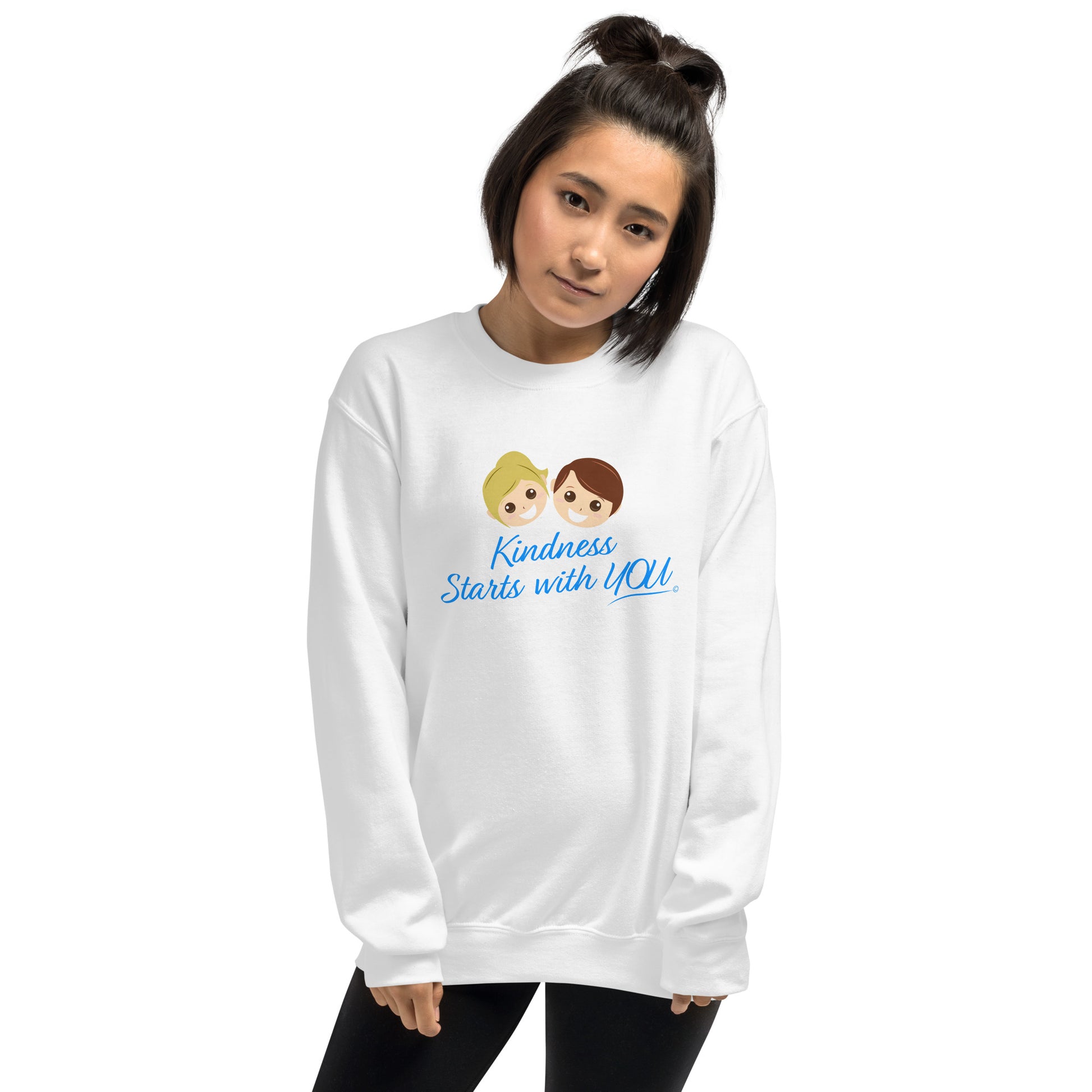 A confident young woman modeling a cozy unisex sweatshirt in white, featuring the uplifting quote 'Kindness Starts with You' in bold lettering.