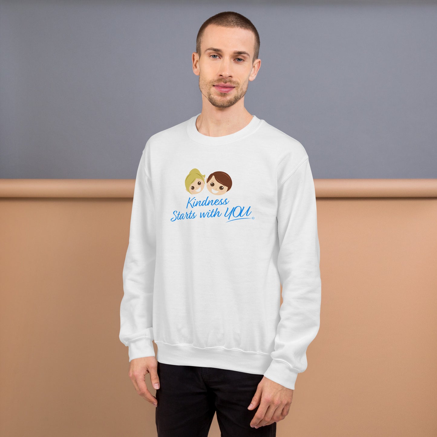 A confident man modeling a cozy unisex sweatshirt in white, featuring the uplifting quote 'Kindness Starts with You' in bold lettering.